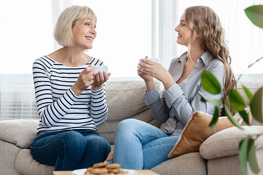 Mother and daughter chatting over cup of tea